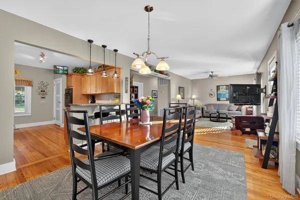 a view of a dining room and livingroom with furniture wooden floor a chandelier