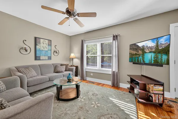 a living room with furniture a window and a flat screen tv