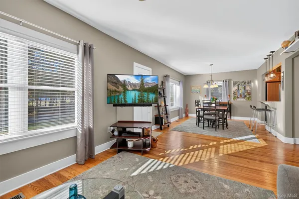 a living room with furniture a flat screen tv and a large window