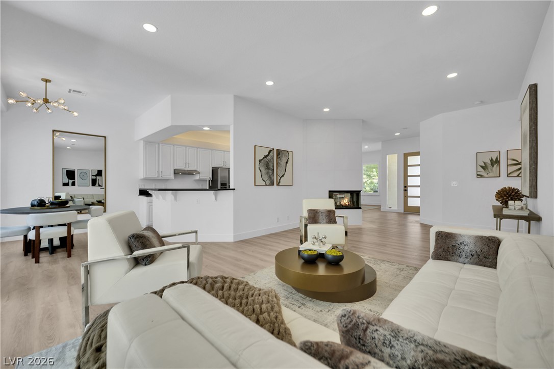 8981 Rivers Edge Drive Las Vegas, NV 89117 - Photo 13 of 69 Open-concept living area with light wood flooring and a modern fireplace.