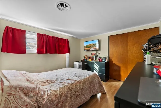 a bedroom with a bed and a flat screen tv