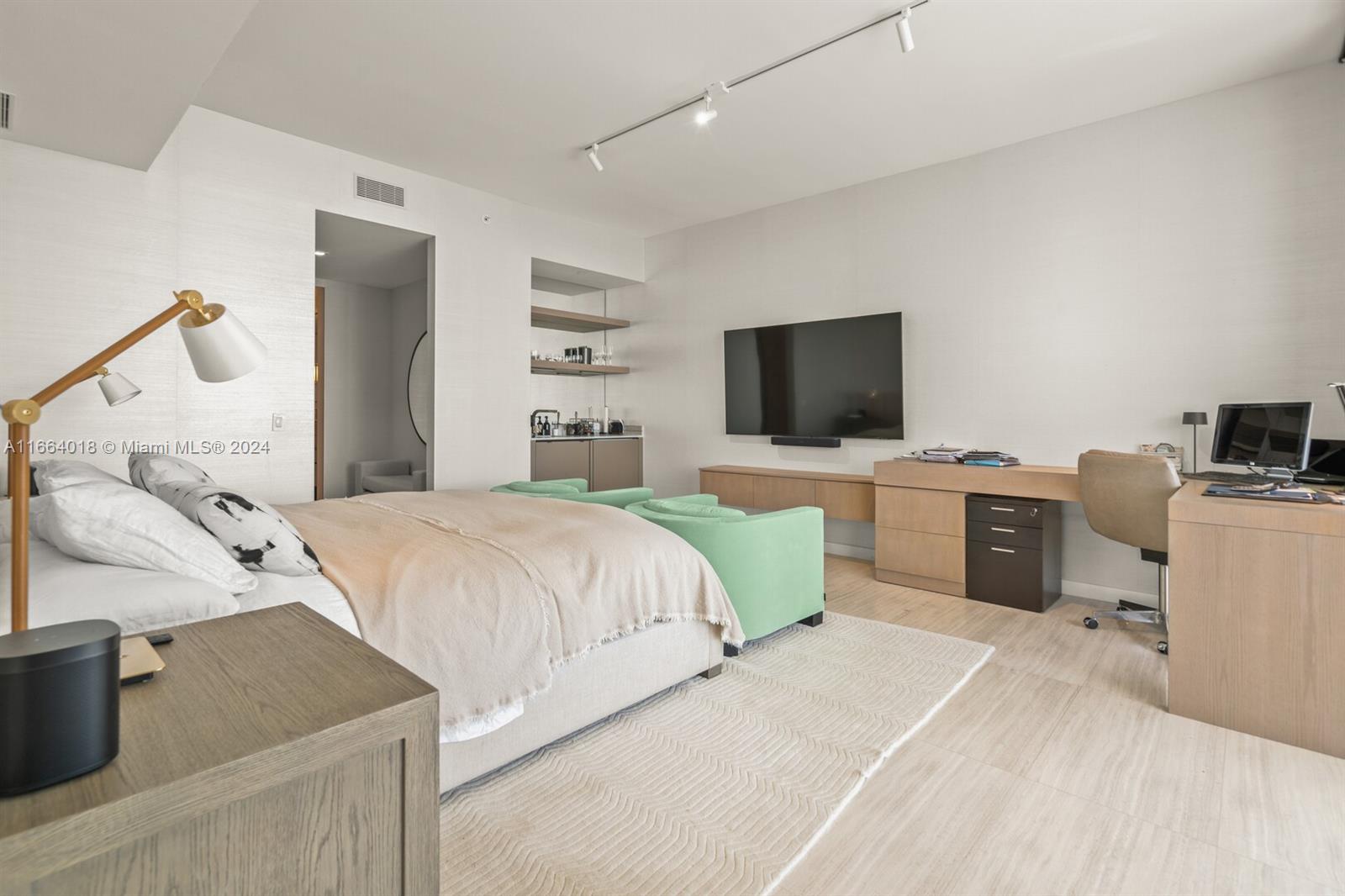 18975 Collins Avenue, Unit 5002 Sunny Isles Beach, FL 33160 - Photo 14 of 37 a bedroom with a bed and flat screen tv