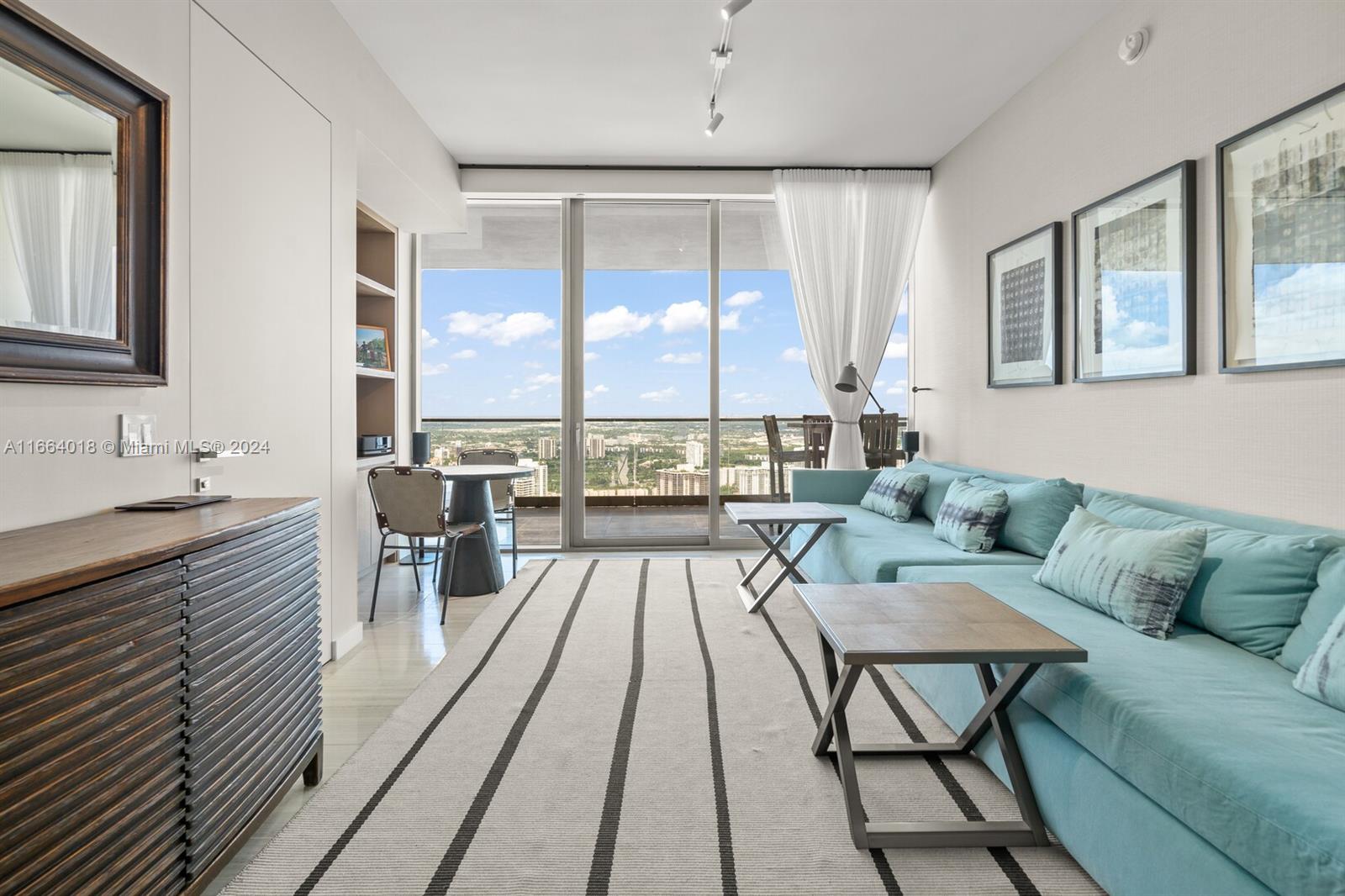 18975 Collins Avenue, Unit 5002 Sunny Isles Beach, FL 33160 - Photo 20 of 37 a living room with furniture and a large window