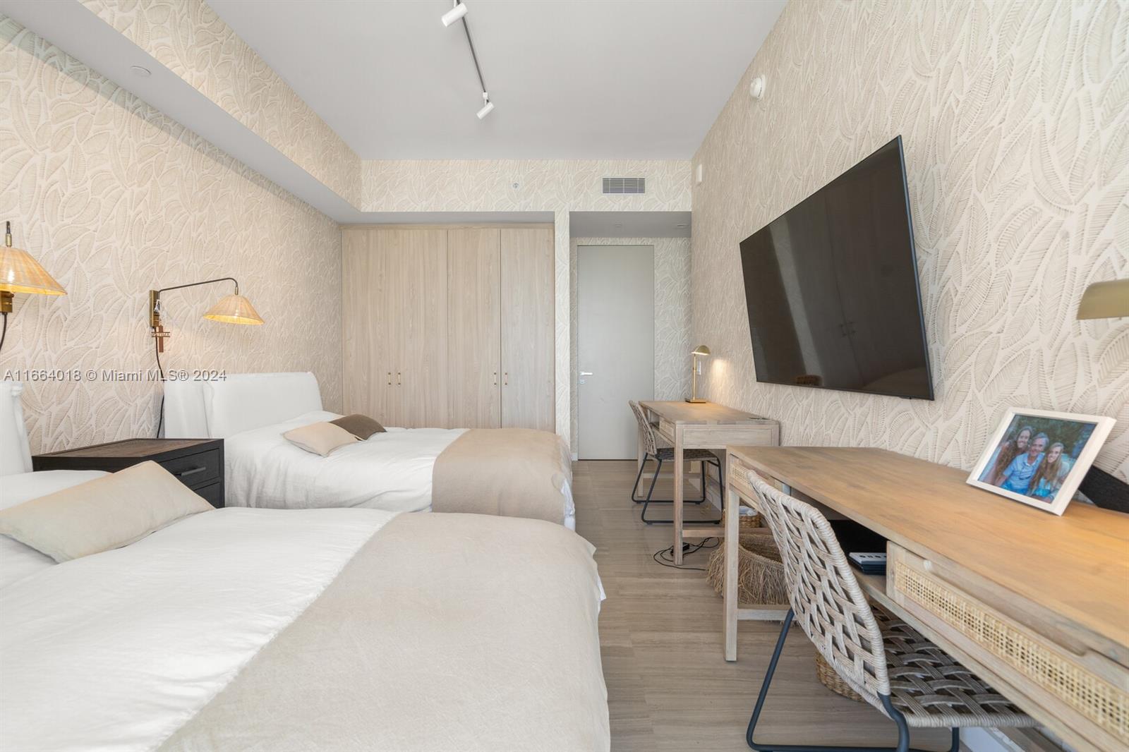 18975 Collins Avenue, Unit 5002 Sunny Isles Beach, FL 33160 - Photo 25 of 37 a bedroom with furniture and a flat screen tv