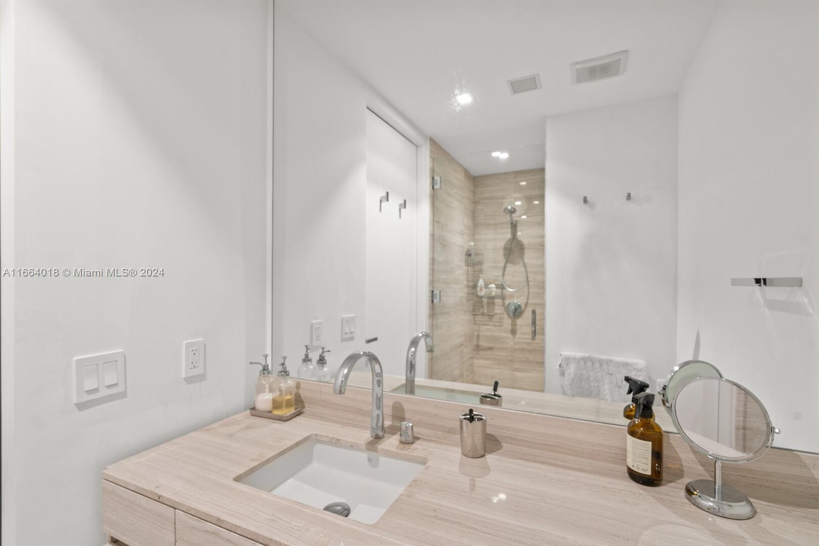 18975 Collins Avenue, Unit 5002 Sunny Isles Beach, FL 33160 - Photo 26 of 37 a bathroom with double vanity sinks and a mirror