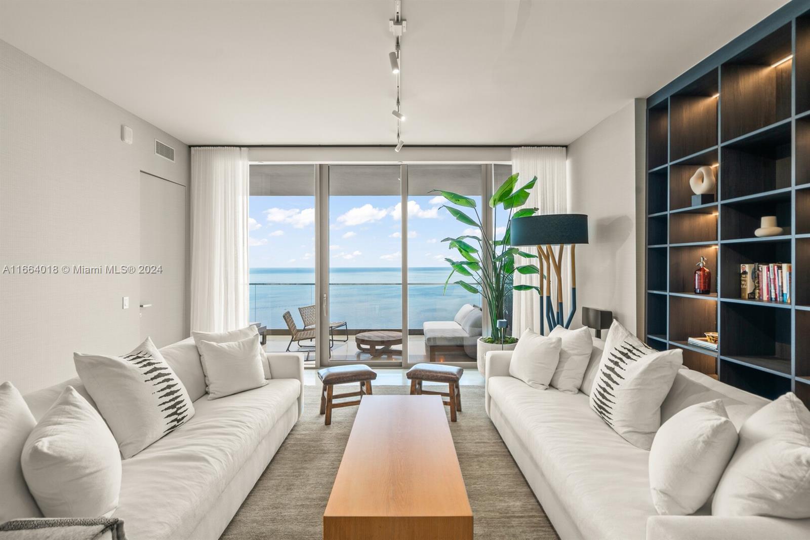 18975 Collins Avenue, Unit 5002 Sunny Isles Beach, FL 33160 - Photo 3 of 37 a living room with furniture and a book shelf