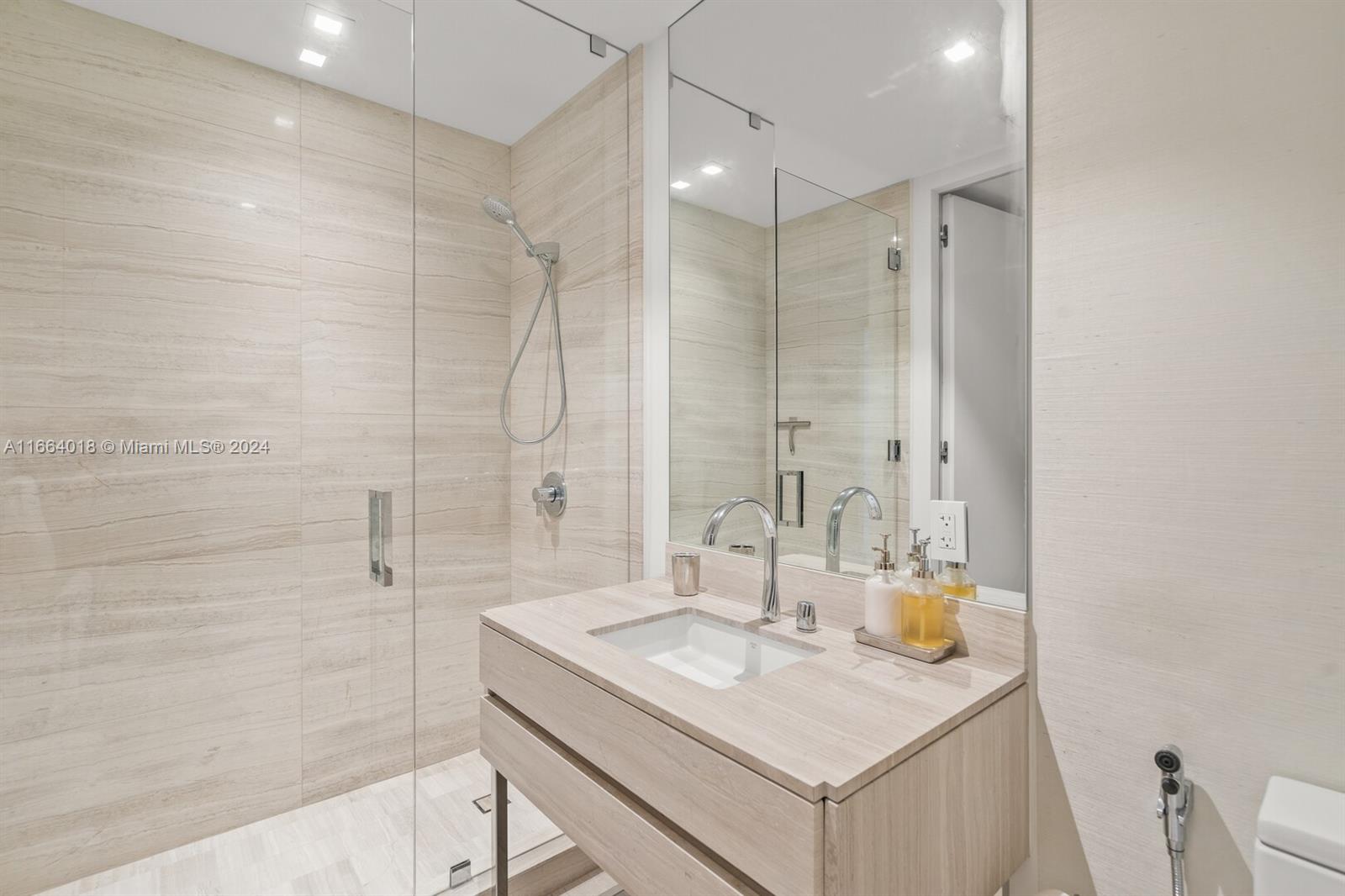 18975 Collins Avenue, Unit 5002 Sunny Isles Beach, FL 33160 - Photo 32 of 37 a bathroom with a sink shower and a mirror