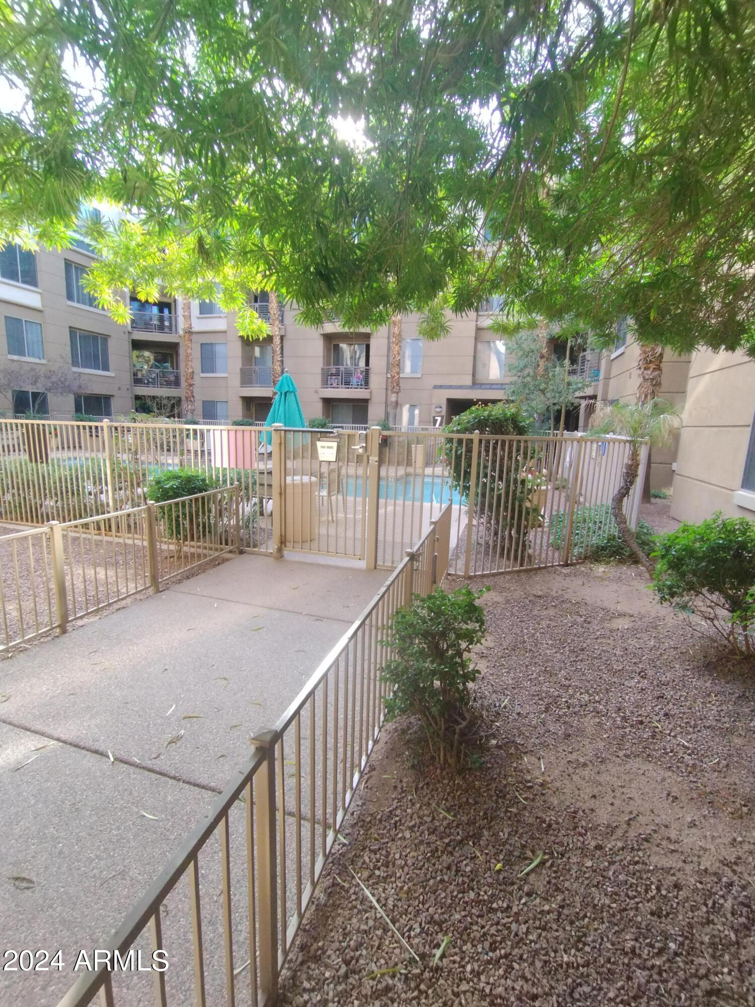 1701 East Colter Street, Unit 165 Phoenix, AZ 85016 - Photo 16 of 33 a view of a pathway with a wrought fence