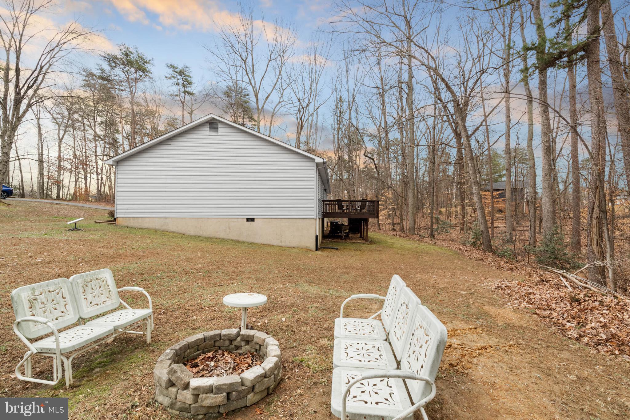 5344 Courtneys Corner Road Sumerduck, VA 22742 - Photo 32 of 56 a backyard of a house with barbeque oven table and chairs