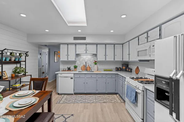 a kitchen with a sink white cabinets and stainless steel appliances