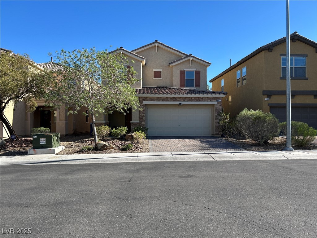 8977 Melridge Road Las Vegas, NV 89148 - Photo 1 of 35 Traditional-style home featuring a tiled roof, an attached garage, driveway, and stucco siding