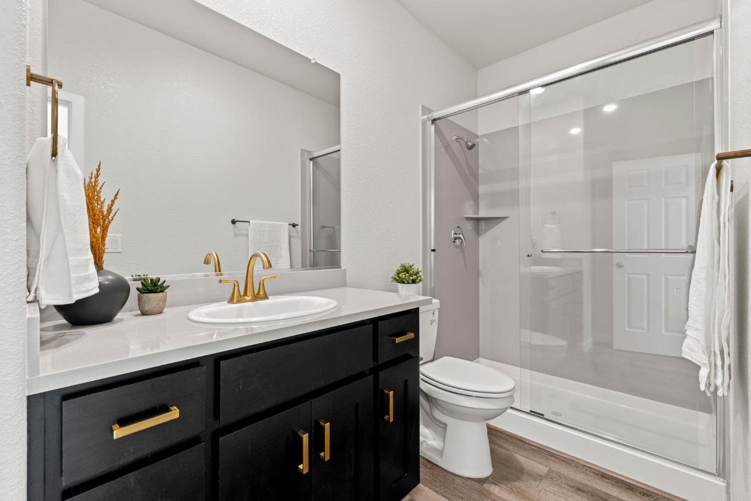3017 Checkerspot Street Roseville, CA 95747 - Photo 30 of 57 a bathroom with a granite countertop sink toilet a mirror and shower