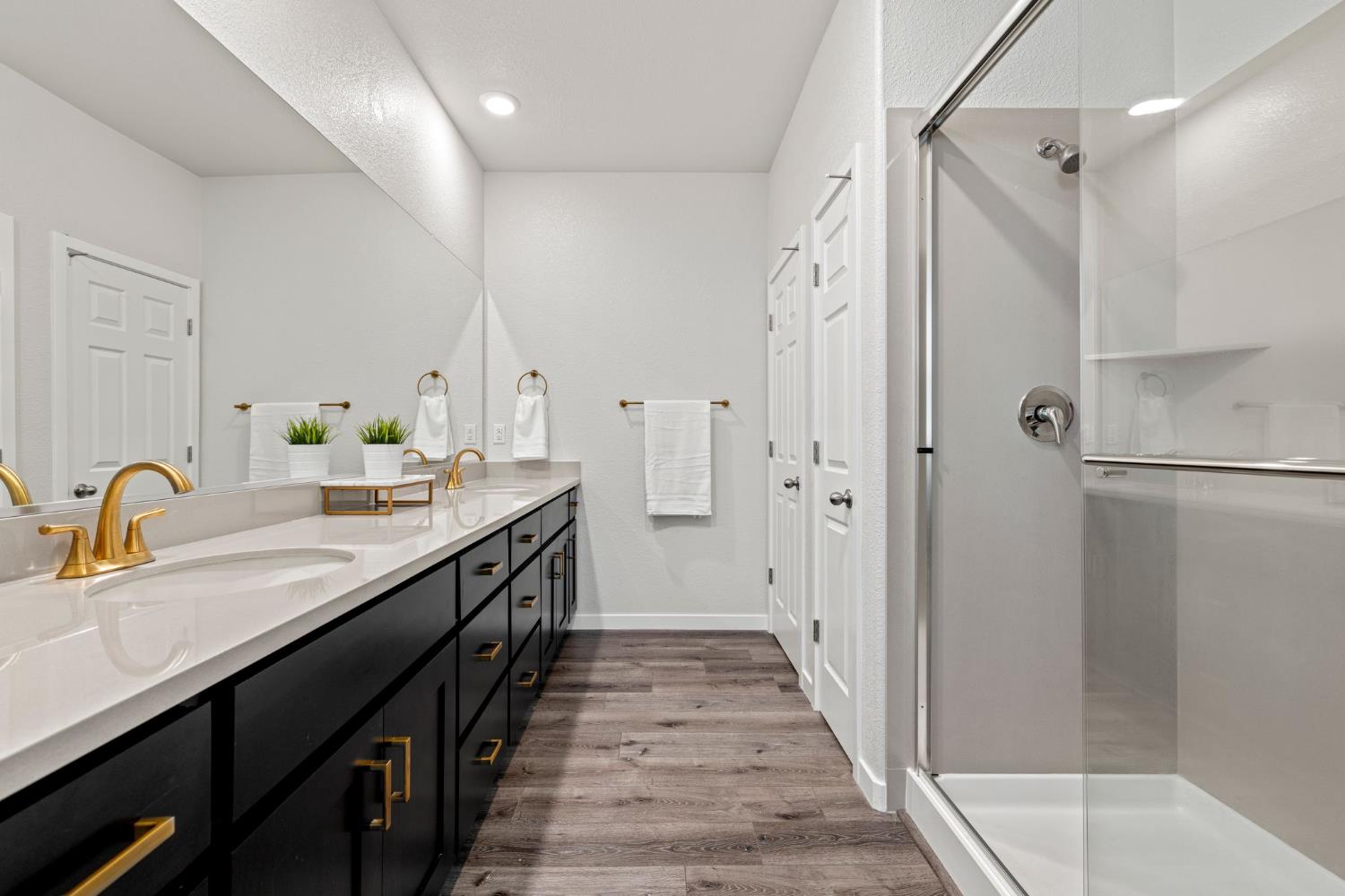 3017 Checkerspot Street Roseville, CA 95747 - Photo 47 of 57 a en suite bathroom with a granite countertop double vanity sink a mirror and a shower