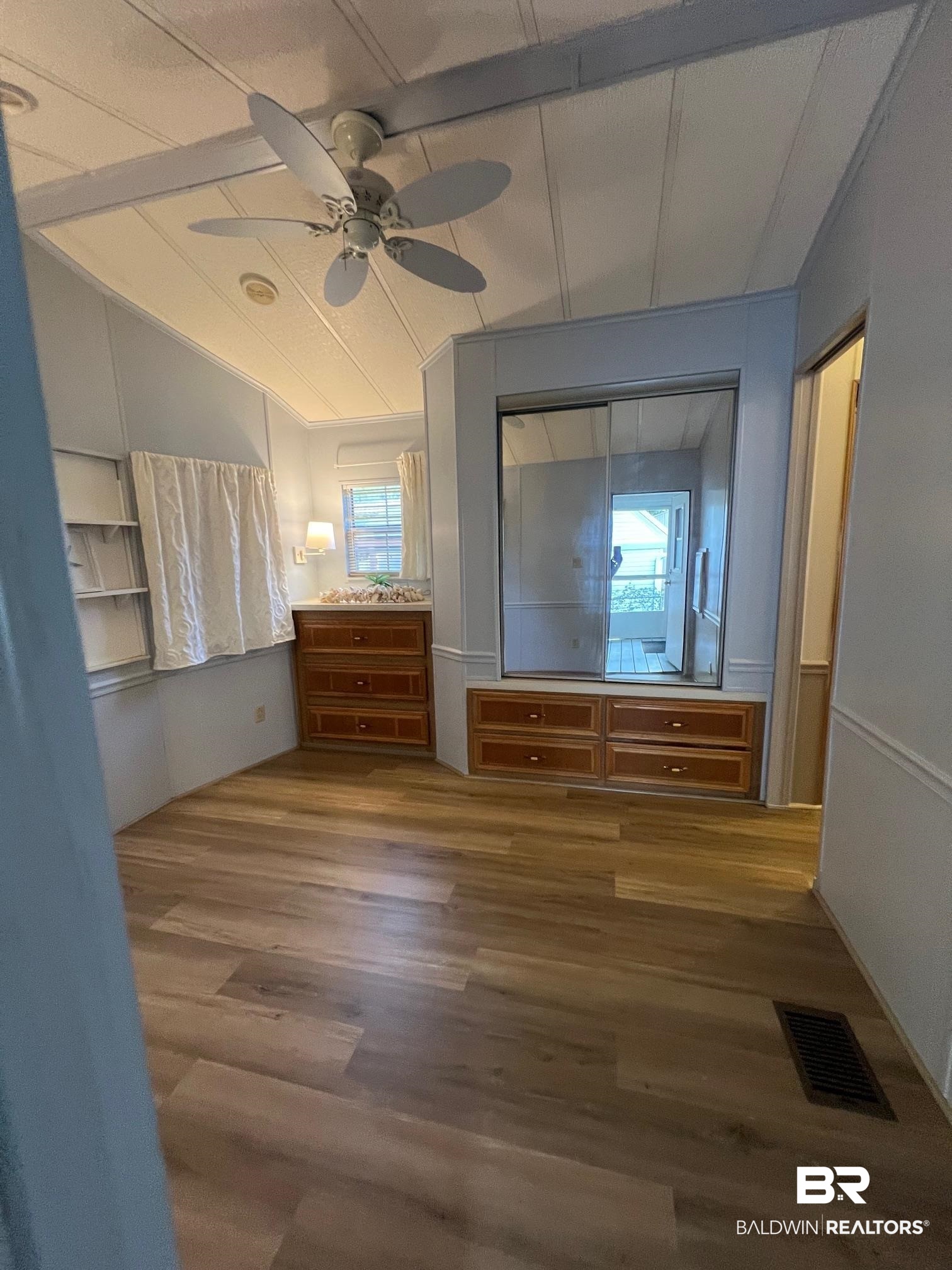 195 Defuniak Loop Lillian, AL 36549 - Photo 11 of 37 Unfurnished bedroom with vaulted ceiling, a closet, a ceiling fan, wood finished floors, and visible vents