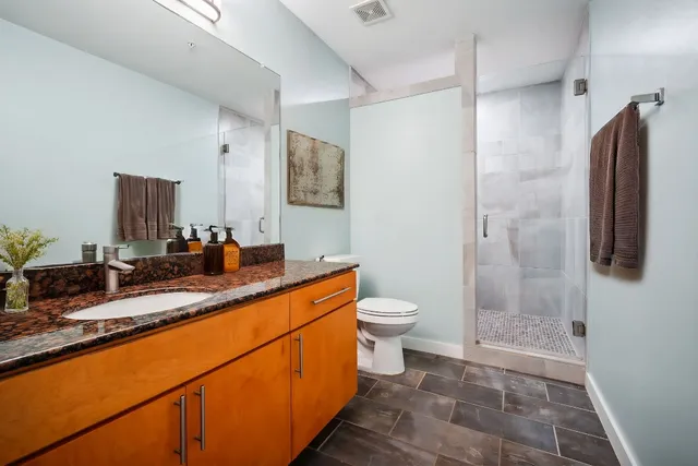 a bathroom with a sink a toilet and shower