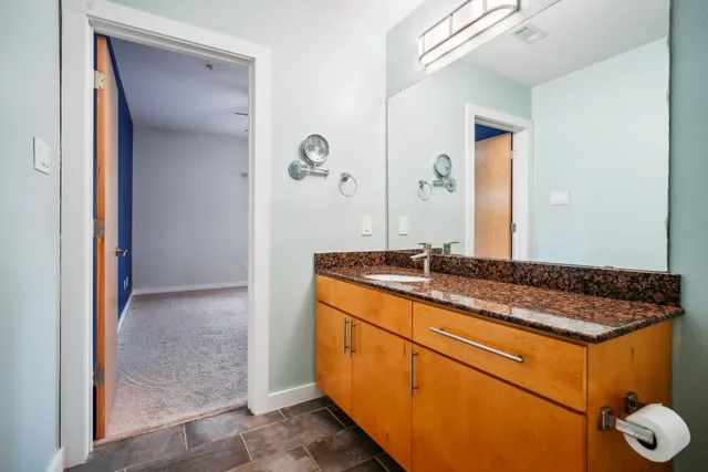 a bathroom with a granite countertop sink and a mirror