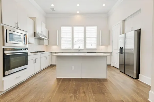 a kitchen with stainless steel appliances a stove a sink and a refrigerator
