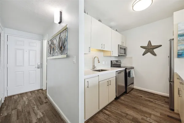 a kitchen with a sink a stove a refrigerator and cabinets