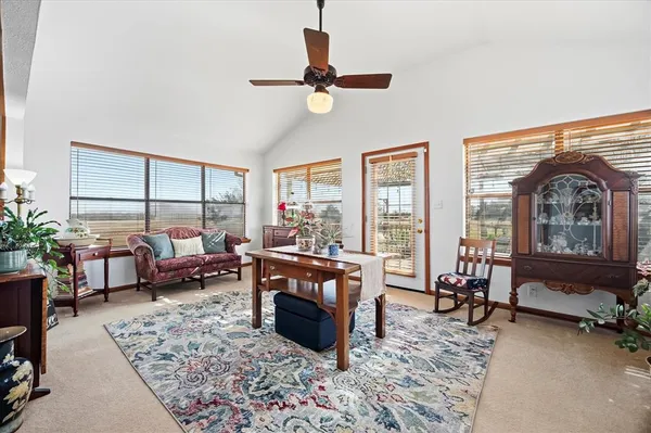 a living room with furniture floor to ceiling window and a table