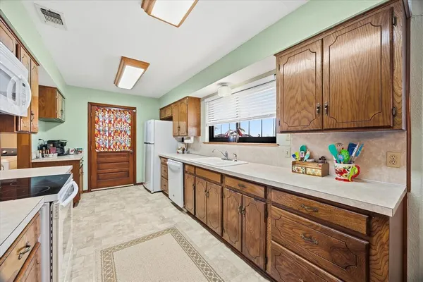 a kitchen with stainless steel appliances granite countertop a refrigerator sink and wooden cabinets