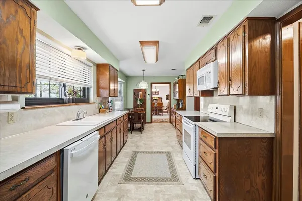 a large kitchen with stainless steel appliances lots of counter space and a sink