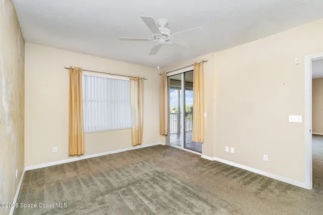 an empty room with closet and ceiling fan