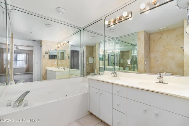 a bathroom with a tub a sink shower and mirror