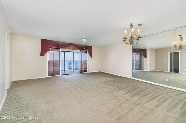 a view of an empty room with a chandelier