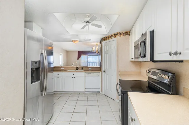 a kitchen with a sink a refrigerator and cabinets