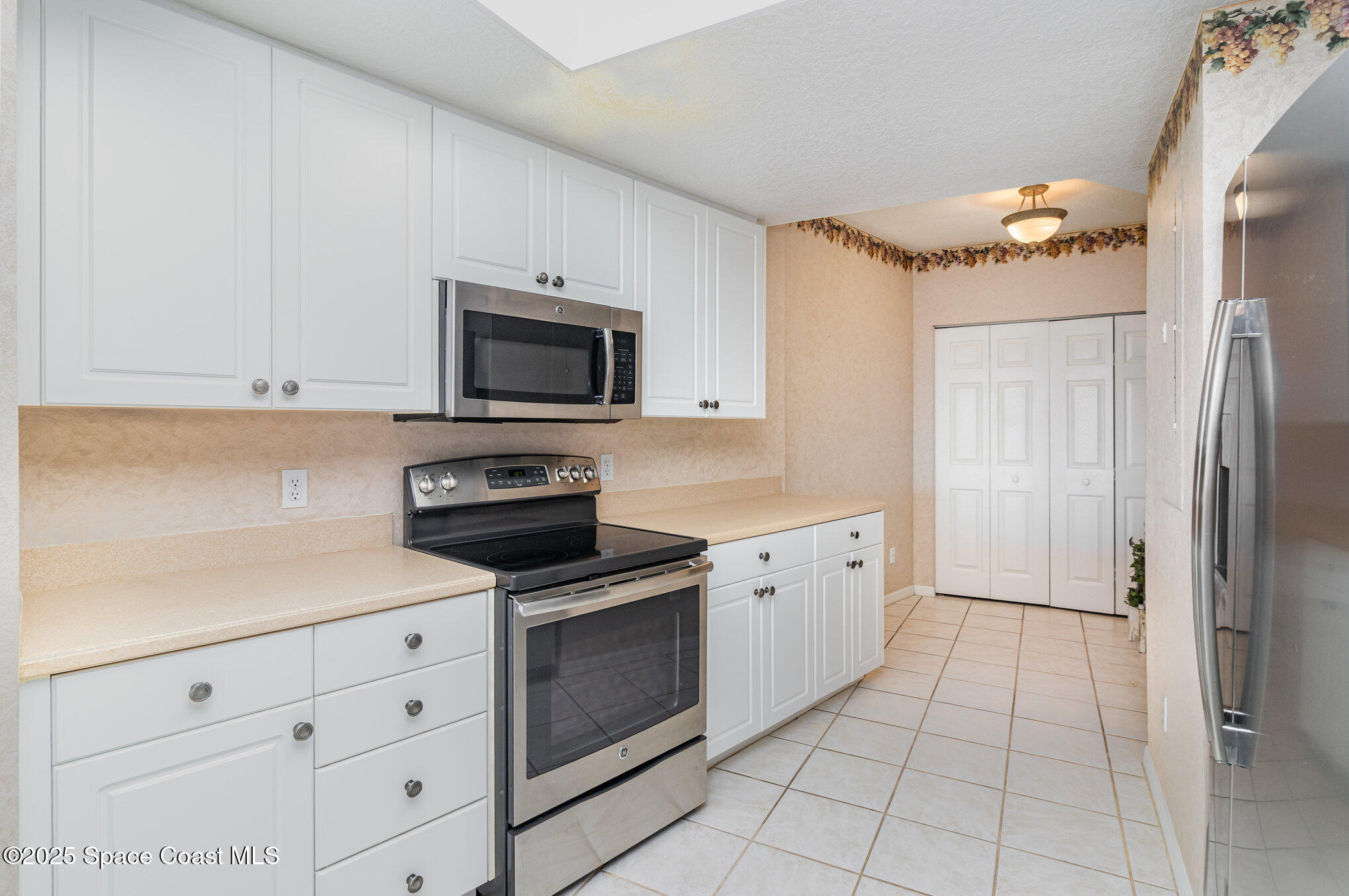 104 Riverside Drive, Unit 403 Cocoa, FL 32922 - Photo 6 of 20 a kitchen with granite countertop a stove a sink and a refrigerator