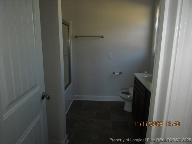 a bathroom with a granite countertop toilet and a sink
