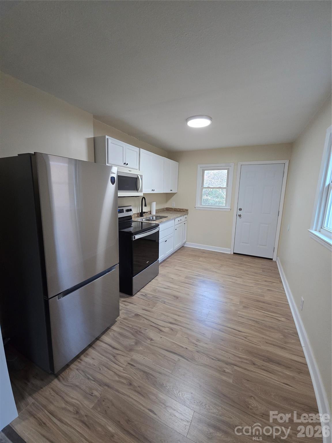 638 Miller Street Charlotte, NC 28203 - Photo 2 of 13 a kitchen with granite countertop a refrigerator and a stove top oven