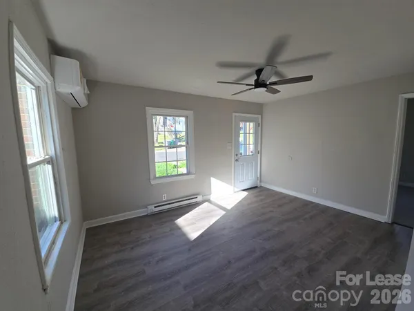 an empty room with windows and fan