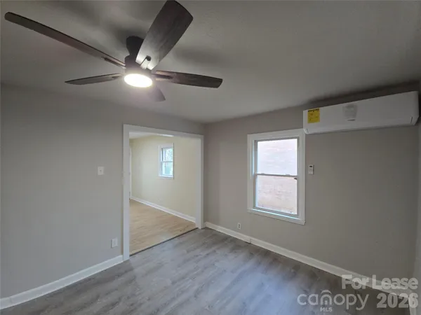 an empty room with windows and fan