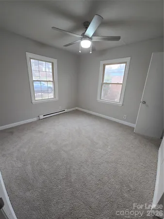 an empty room with a window and a fan