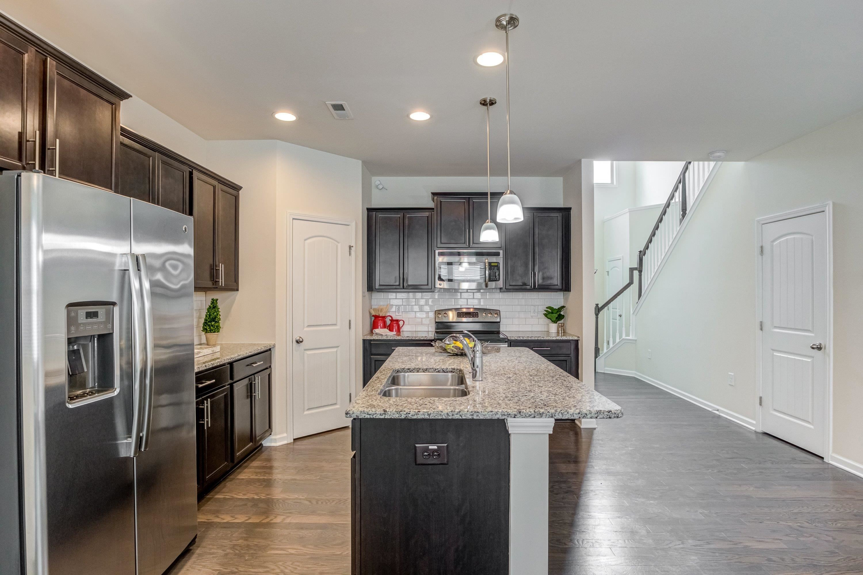 7817 Elmshire Way Raleigh, NC 27616 - Photo 13 of 46 a kitchen with stainless steel appliances granite countertop a sink a stove and a refrigerator