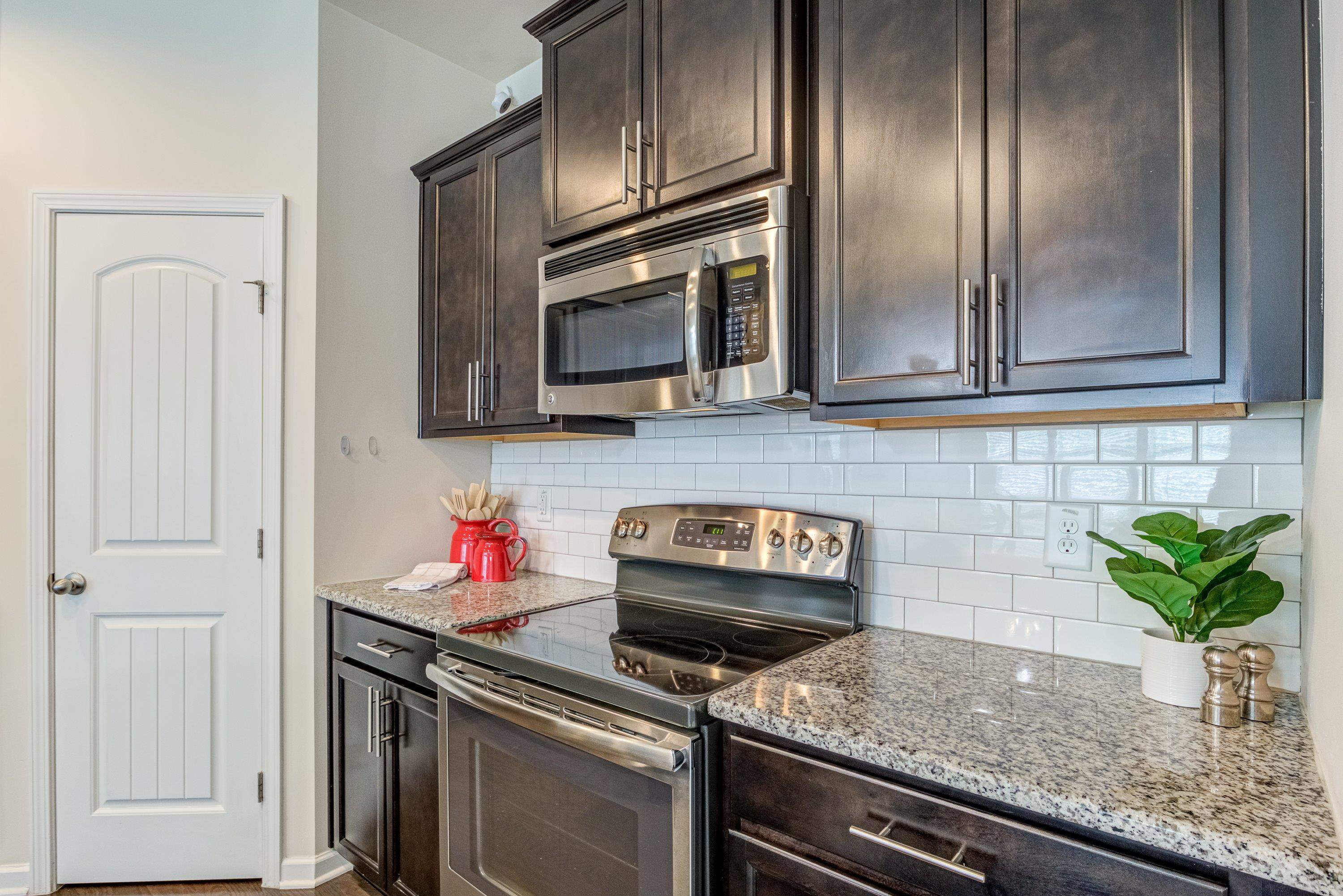 7817 Elmshire Way Raleigh, NC 27616 - Photo 15 of 46 a kitchen with stainless steel appliances granite countertop a sink a stove and cabinets