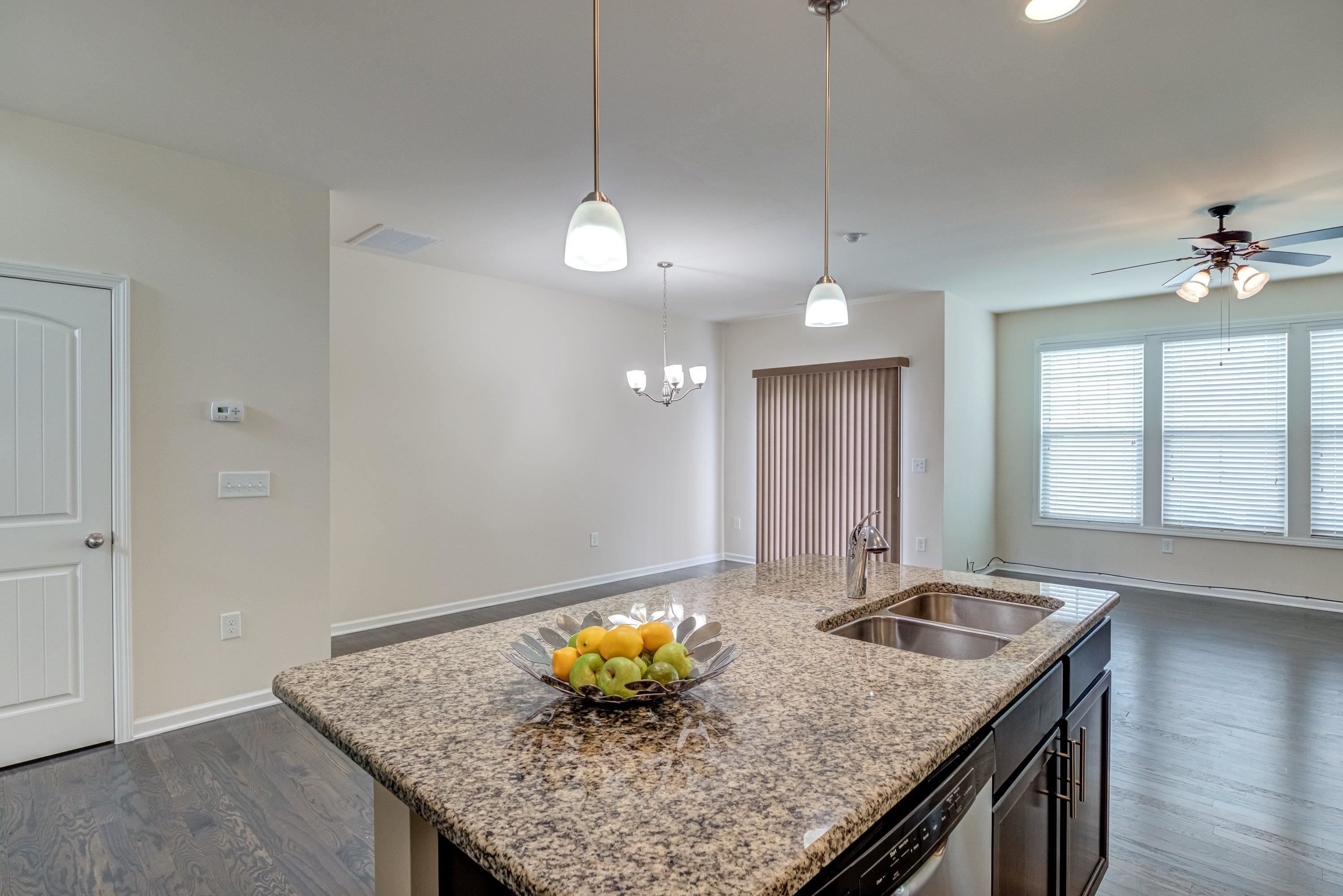 7817 Elmshire Way Raleigh, NC 27616 - Photo 16 of 46 a kitchen with a sink a kitchen island and chairs