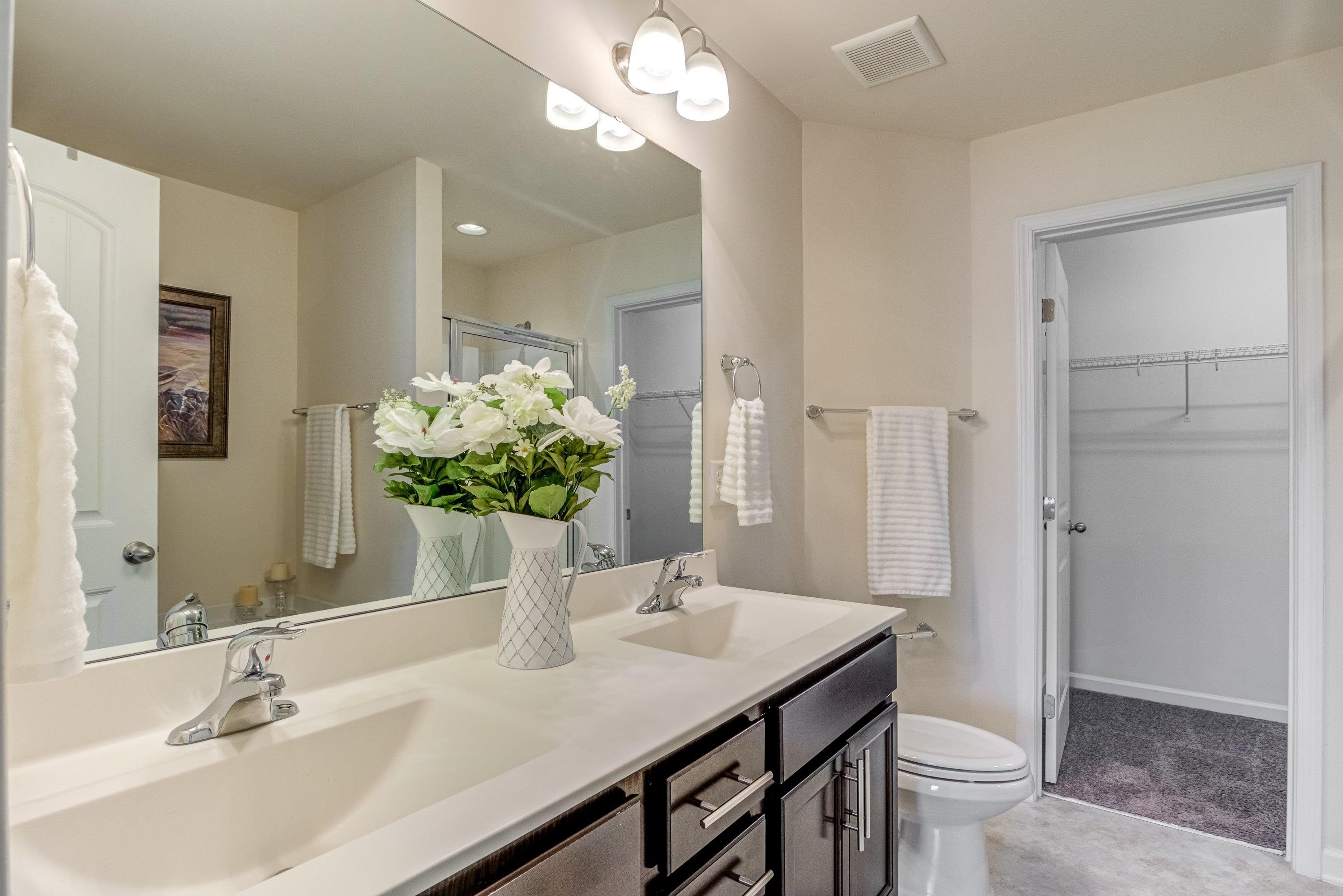 7817 Elmshire Way Raleigh, NC 27616 - Photo 27 of 46 a bathroom with a sink a toilet and a large mirror