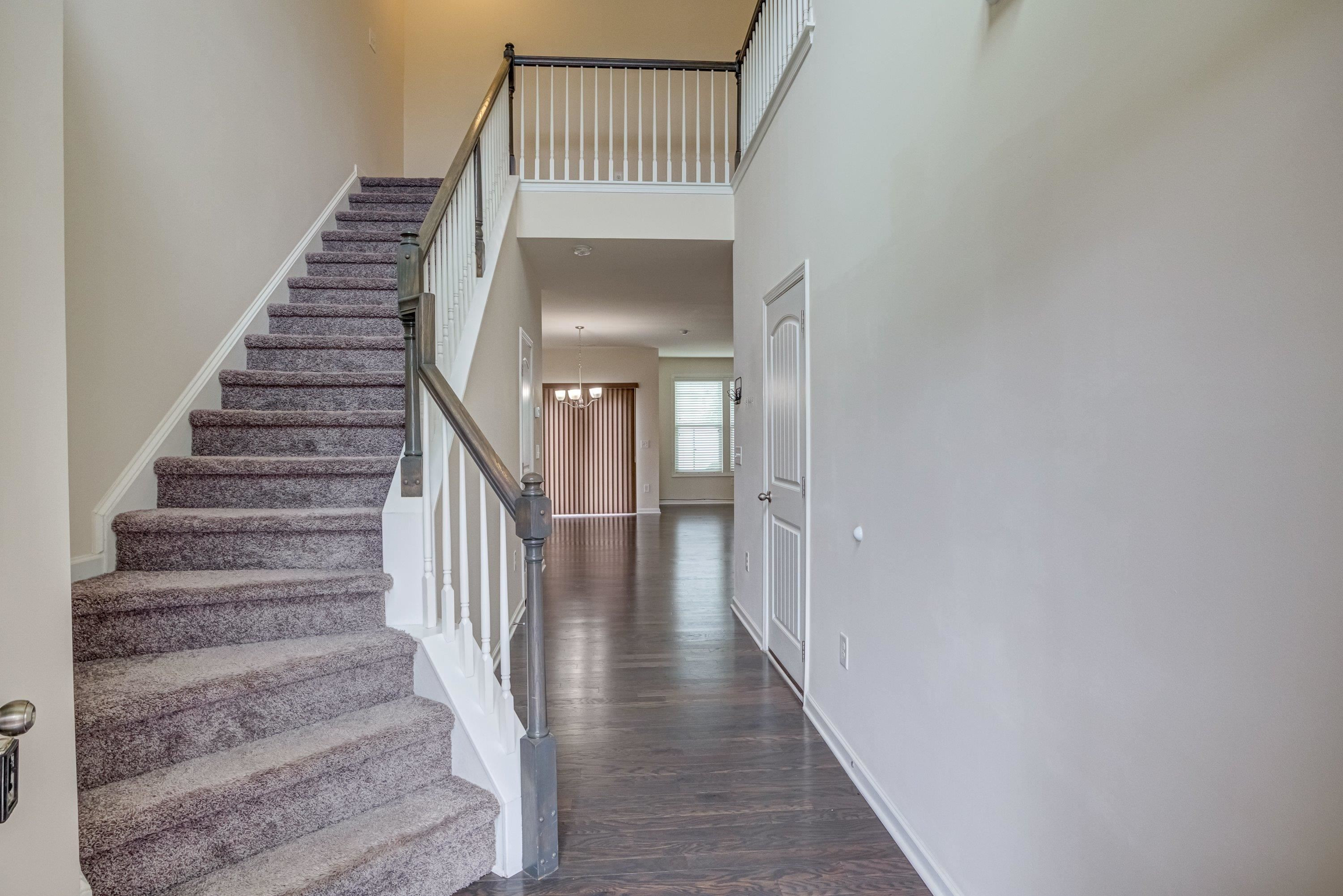7817 Elmshire Way Raleigh, NC 27616 - Photo 6 of 46 a view of staircase with wooden floor and white walls
