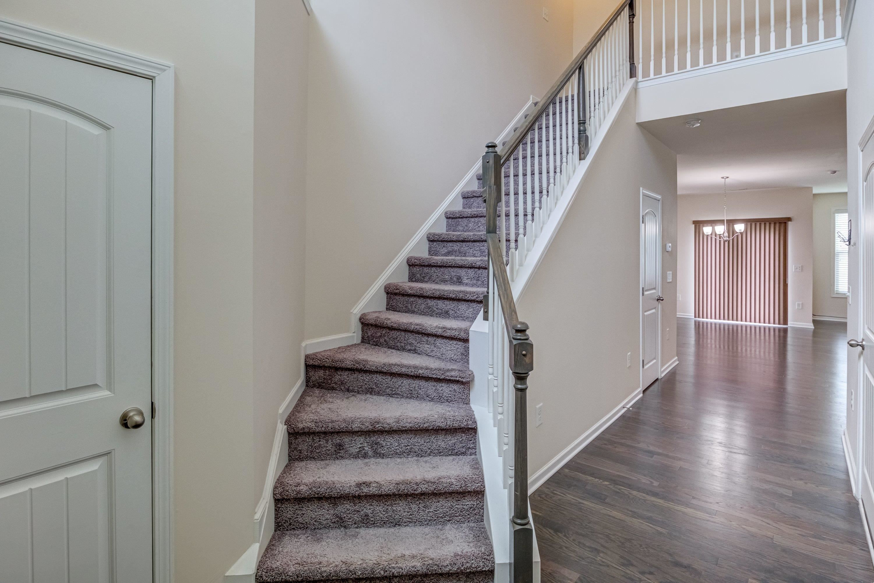 7817 Elmshire Way Raleigh, NC 27616 - Photo 7 of 46 a view of staircase with lots of frames on wall and wooden floor