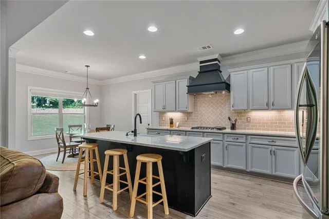 a kitchen with stainless steel appliances granite countertop a sink a stove and a refrigerator