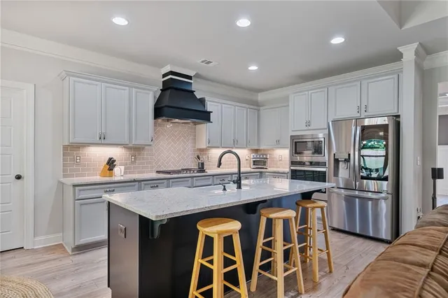 a kitchen with stainless steel appliances granite countertop a stove and a sink