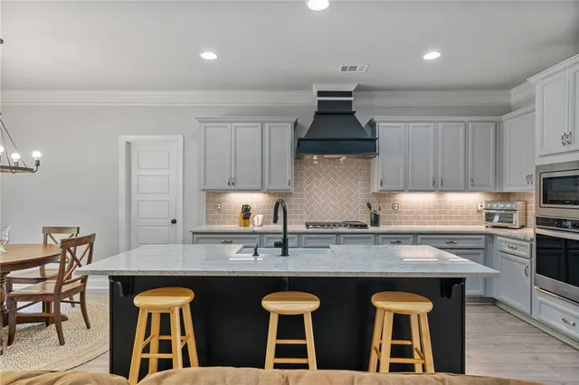 a kitchen with stainless steel appliances granite countertop a sink a stove and cabinets