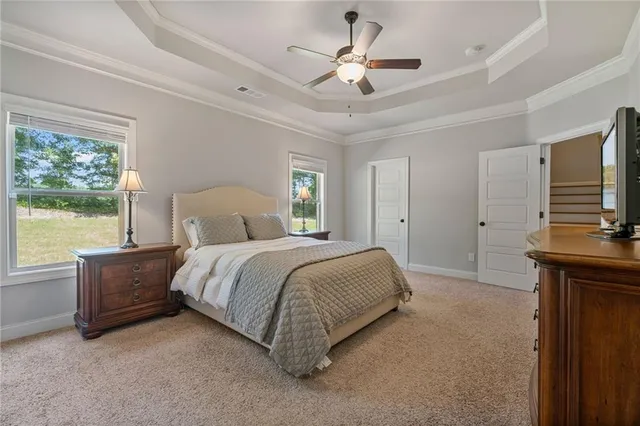 a spacious bedroom with a bed and a flat screen tv