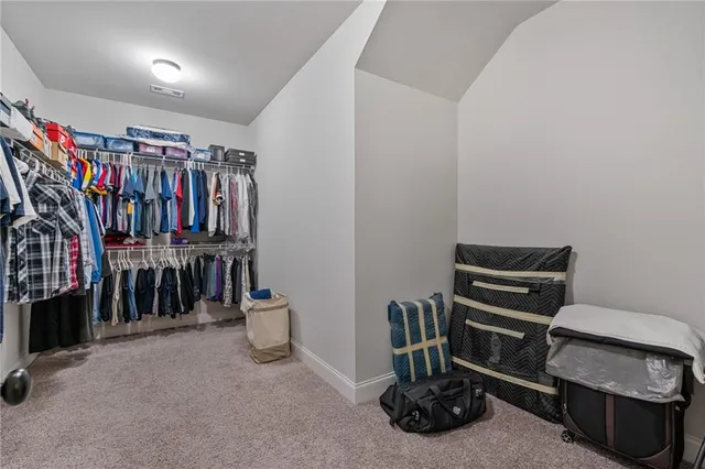 a view of walk in closet with clothes and shoes
