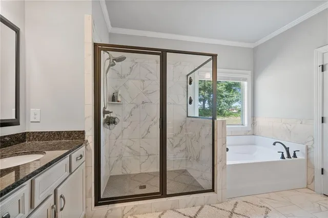 a bathroom with a granite countertop bathtub a mirror and a shower