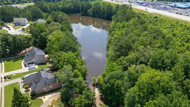 an aerial view of residential house with outdoor space and trees all around