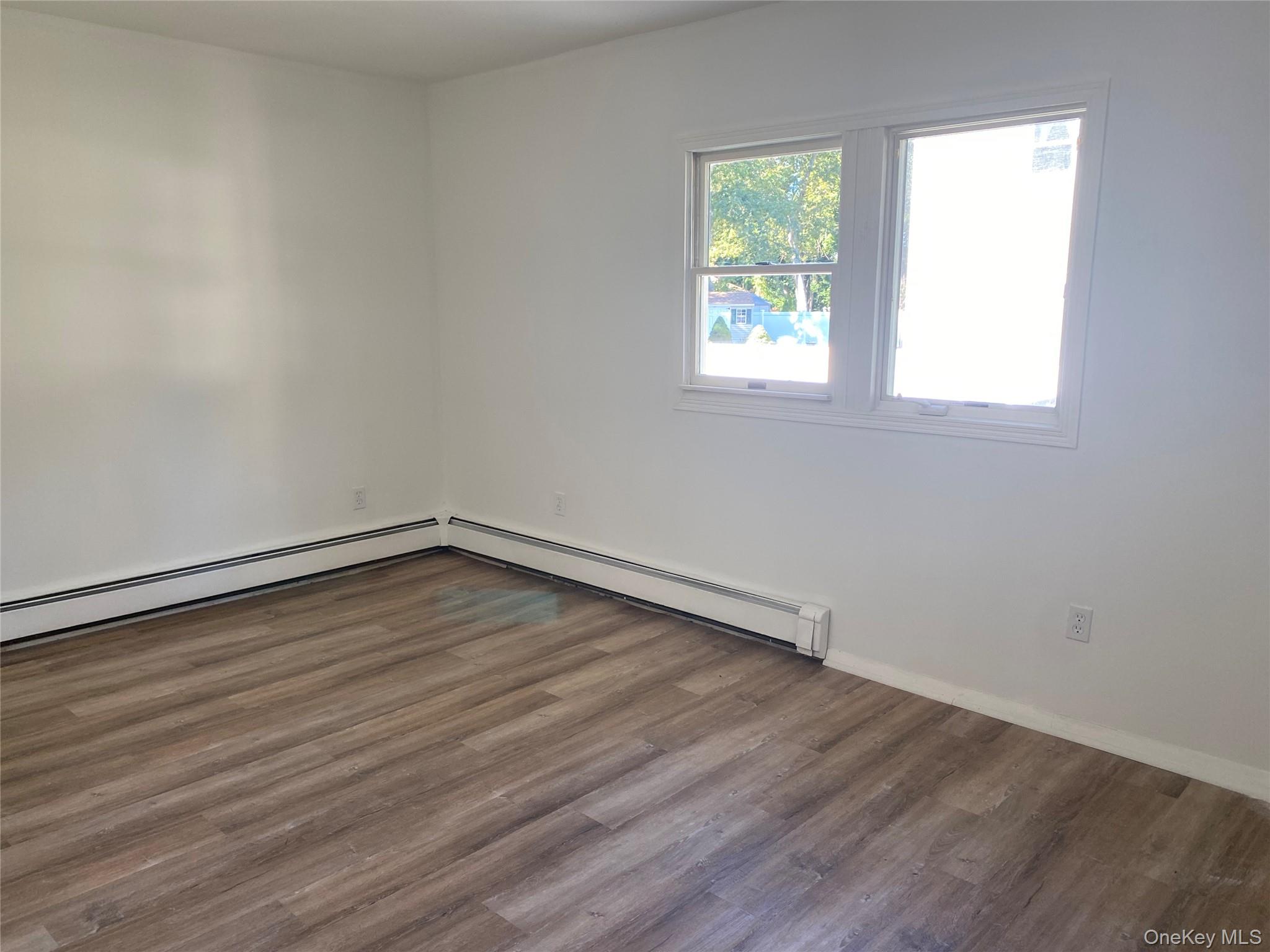 7 Filmore Avenue Coram, NY 11727 - Photo 12 of 22 an empty room with wooden floor and windows