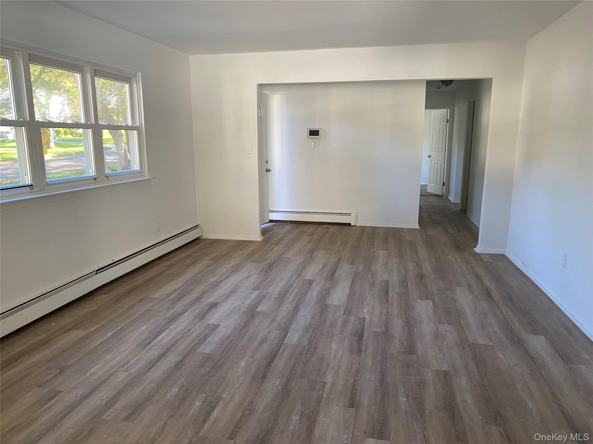 7 Filmore Avenue Coram, NY 11727 - Photo 5 of 22 an empty room with wooden floor and windows